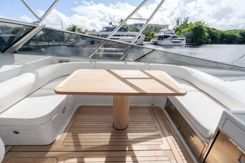 Prana Yacht Photos Pics Luxurious seating area on a 1995 Itama 46 yacht with wooden table and scenic water view.