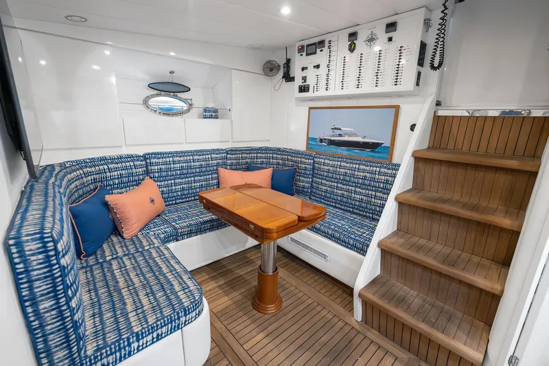 Prana Yacht Photos Pics Luxurious interior of a 1995 Itama 46 yacht with blue seating and wooden flooring.