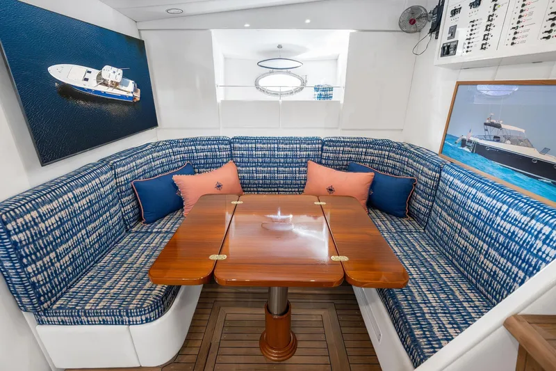 Prana Yacht Photos Pics Luxurious interior of a 1995 Itama 46 yacht with blue patterned seating and wooden table.