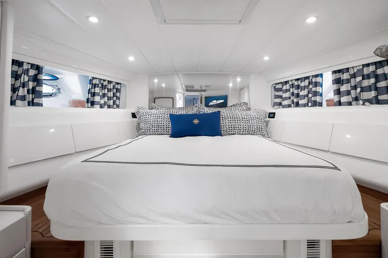Prana Yacht Photos Pics Luxurious cabin interior of a 1995 Itama 46 yacht with elegant bedding and striped curtains.