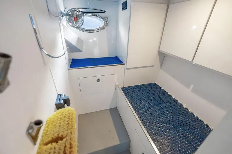 Prana Yacht Photos Pics Interior of 1995 Itama 46 yacht, featuring white cabinetry and blue accents.