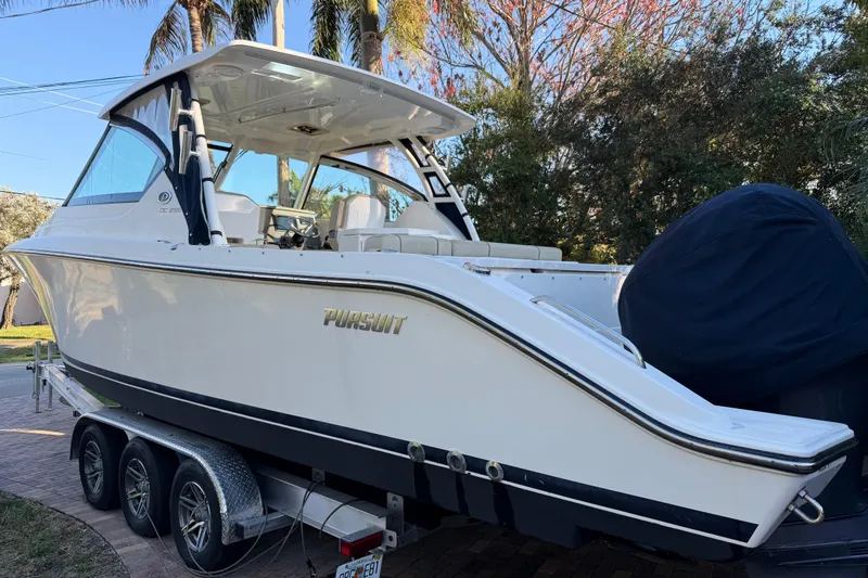  Yacht Photos Pics 2017 Pursuit DC 295 Dual Console boat on trailer, parked outdoors.