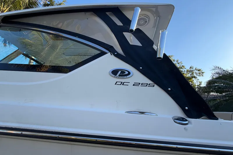  Yacht Photos Pics 2017 Pursuit DC 295 Dual Console boat side view with logo and palm trees.