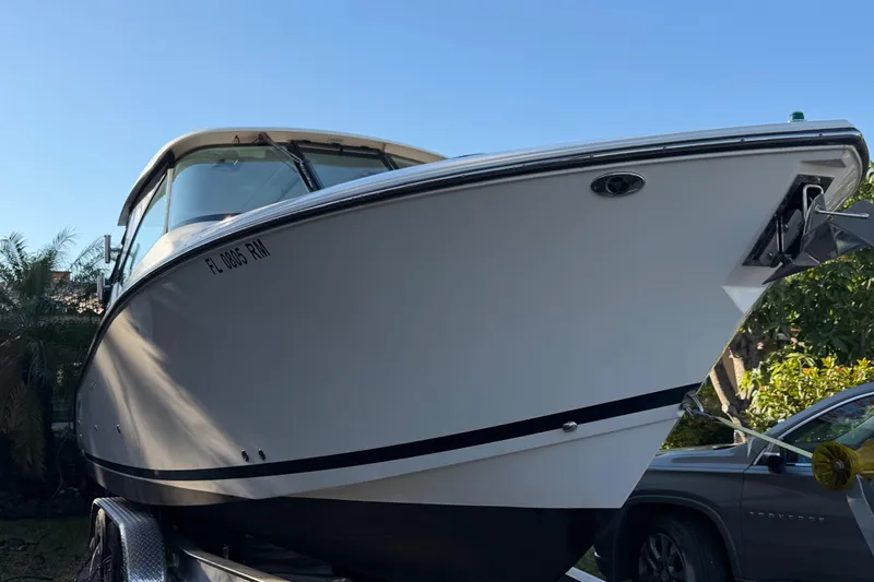  Yacht Photos Pics 2017 Pursuit DC 295 Dual Console boat on trailer, side view under clear blue sky.