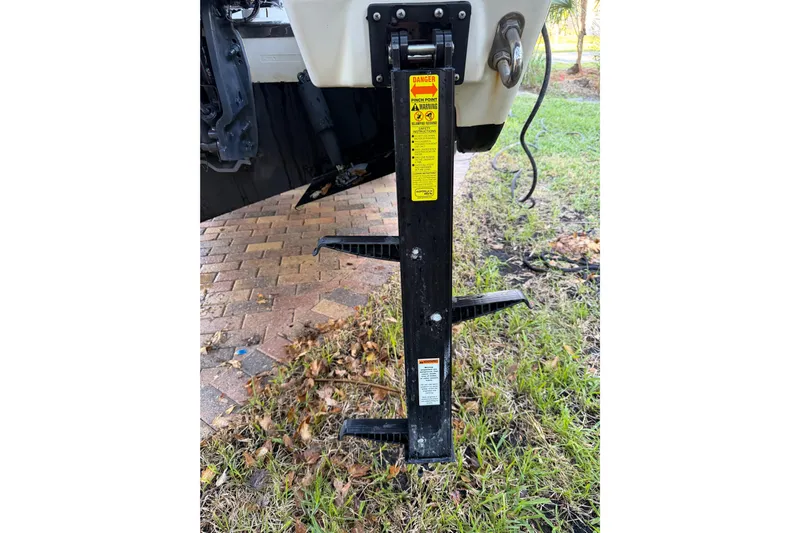  Yacht Photos Pics 2017 Pursuit DC 295 Dual Console boat trailer jack on grassy area.