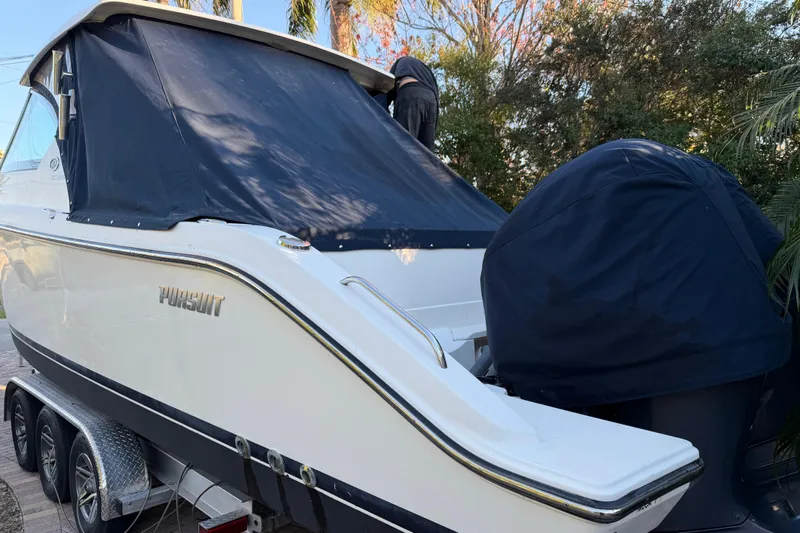  Yacht Photos Pics 2017 Pursuit DC 295 Dual Console boat on trailer, covered and parked outdoors.