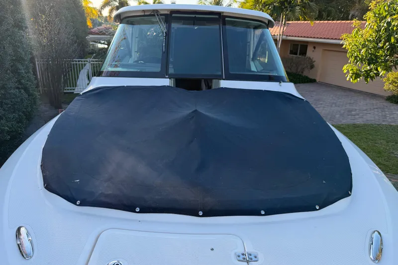  Yacht Photos Pics 2017 Pursuit DC 295 Dual Console boat with black cover, parked in a residential driveway.