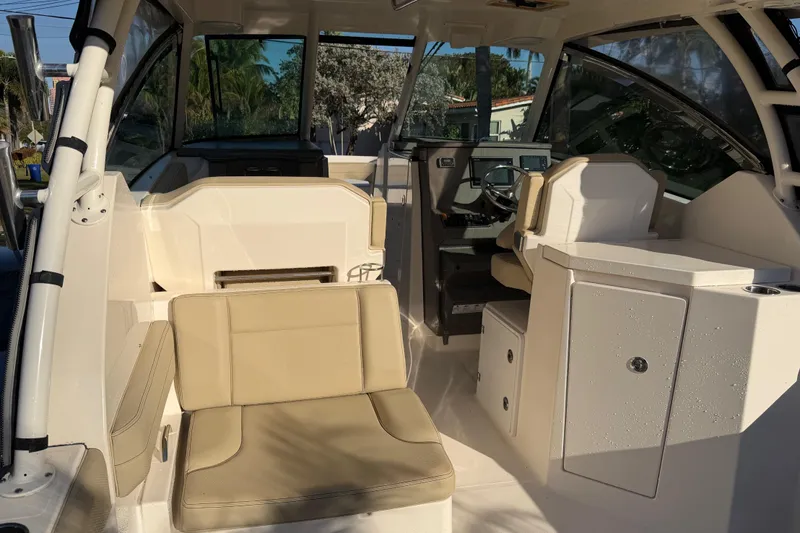  Yacht Photos Pics 2017 Pursuit DC 295 Dual Console boat interior with beige seating and helm station.