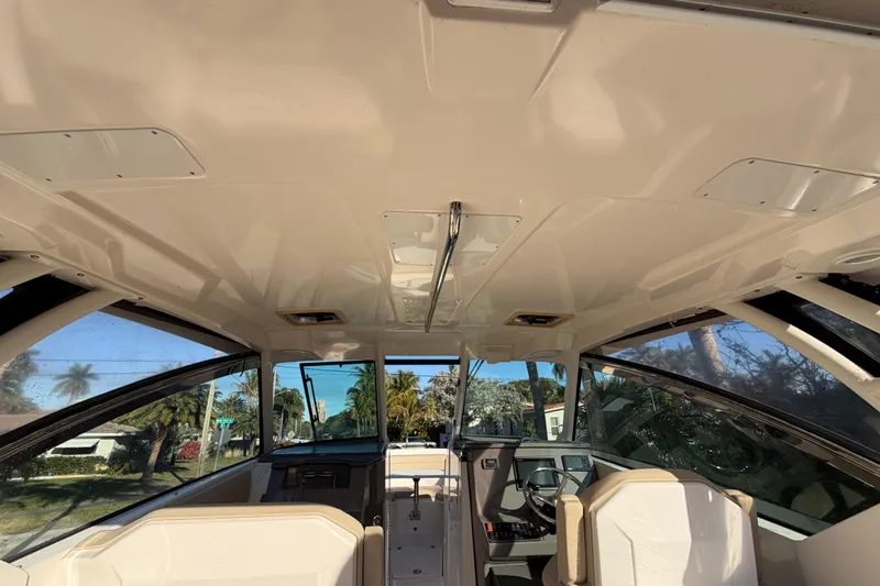  Yacht Photos Pics Interior view of 2017 Pursuit DC 295 Dual Console boat, showcasing helm and seating area.