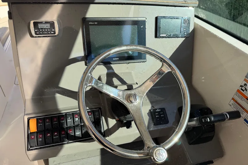  Yacht Photos Pics 2017 Pursuit DC 295 Dual Console boat dashboard with steering wheel and navigation controls.