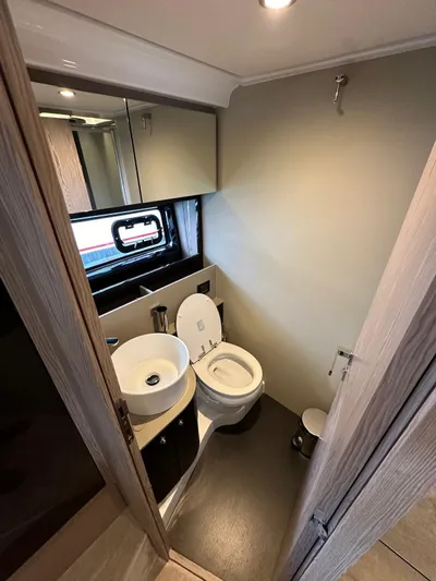  Yacht Photos Pics Luxurious bathroom in 2022 Azimut Atlantis 51 yacht with modern fixtures and porthole window.