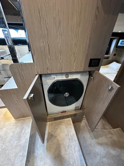  Yacht Photos Pics Built-in washing machine on Azimut Atlantis 51 yacht, 2022 model, with wooden cabinetry.