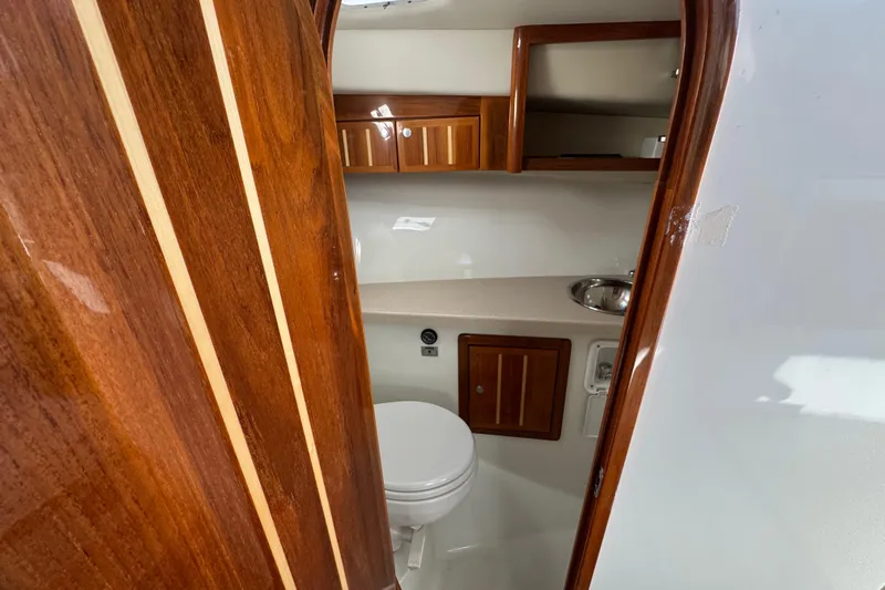  Yacht Photos Pics 2005 Ocean Sport Roamer 30 boat interior with wooden cabinetry and compact bathroom.