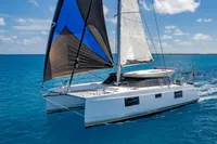 2021 Nautitech 40 Open catamaran sailing on clear blue ocean waters.