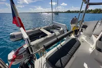 Nautitech 40 Open 2021 catamaran with dinghy, anchored in clear blue waters.