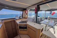 Modern kitchen and dining area on 2021 Nautitech 40 Open catamaran with ocean view.