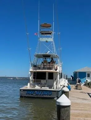 Dry-hydro Yacht Photos Pics 1990 Viking Convertible yacht docked at a marina under clear blue skies.