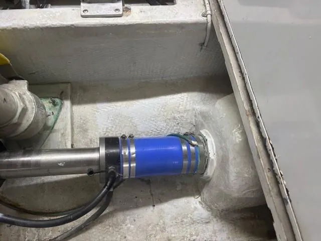 Dry-hydro Yacht Photos Pics Engine compartment of a 1990 Viking Convertible boat, showing mechanical components and blue hose.