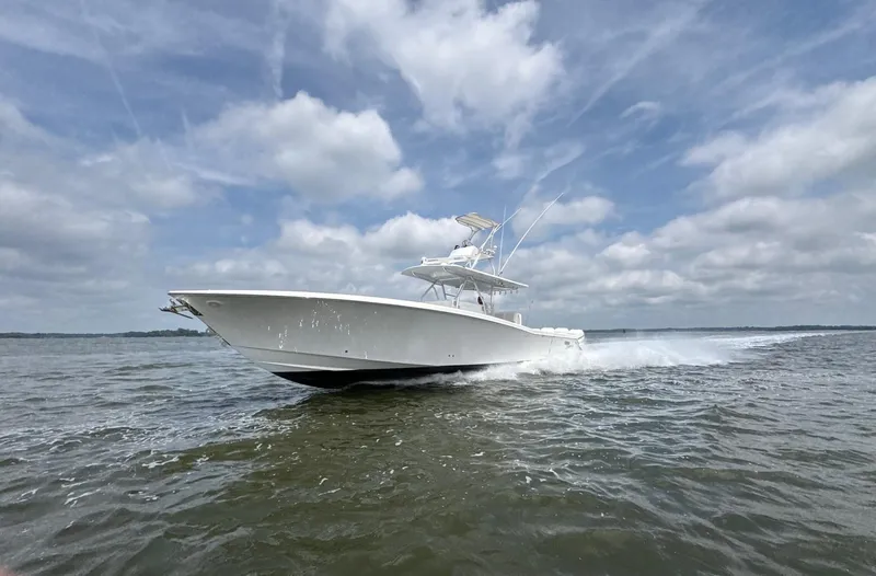Must Sell!! Yacht Photos Pics 2016 Invincible 42 Open Fisherman boat cruising on open water under cloudy skies.