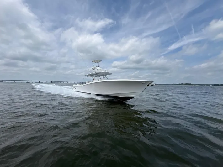 Must Sell!! Yacht Photos Pics 2016 Invincible 42 Open Fisherman boat cruising on open water under cloudy skies.