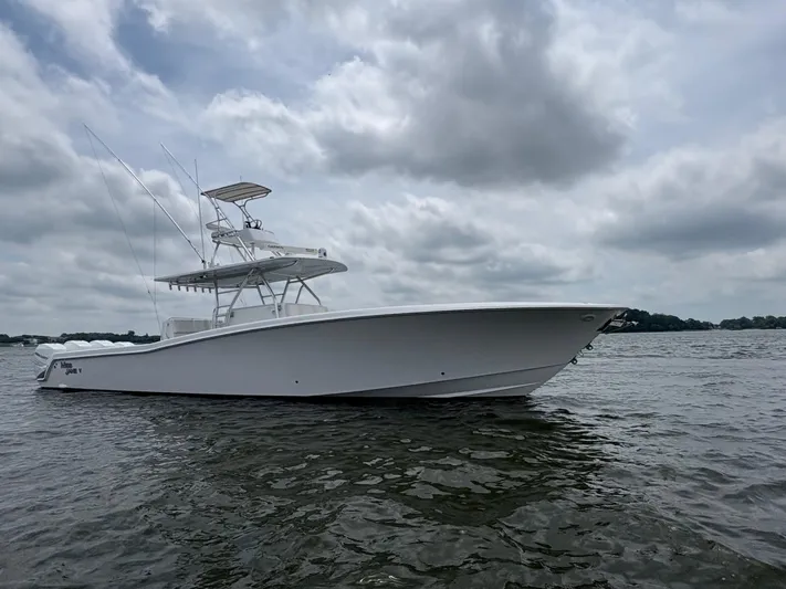 Must Sell!! Yacht Photos Pics 2016 Invincible 42 Open Fisherman boat on water under cloudy sky.