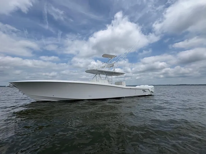 Must Sell!! Yacht Photos Pics 2016 Invincible 42 Open Fisherman boat on calm water under cloudy sky.