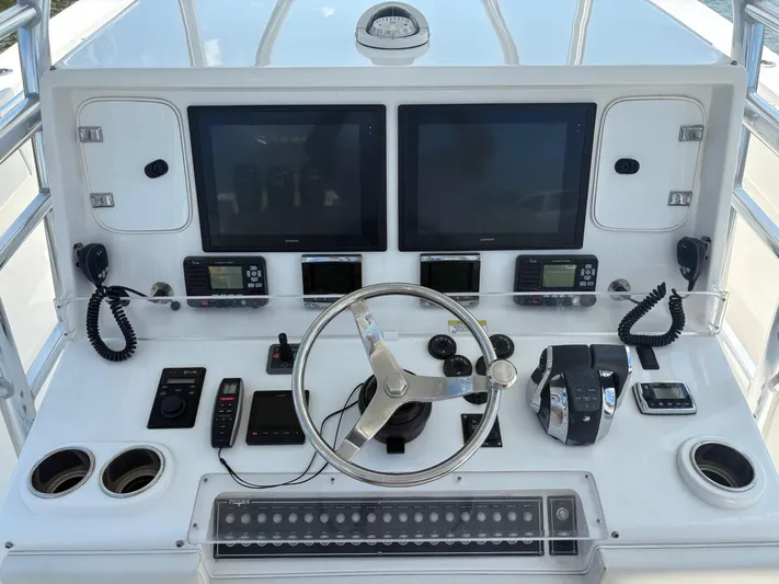 Must Sell!! Yacht Photos Pics Control panel of 2016 Invincible 42 Open Fisherman boat with dual screens and steering wheel.