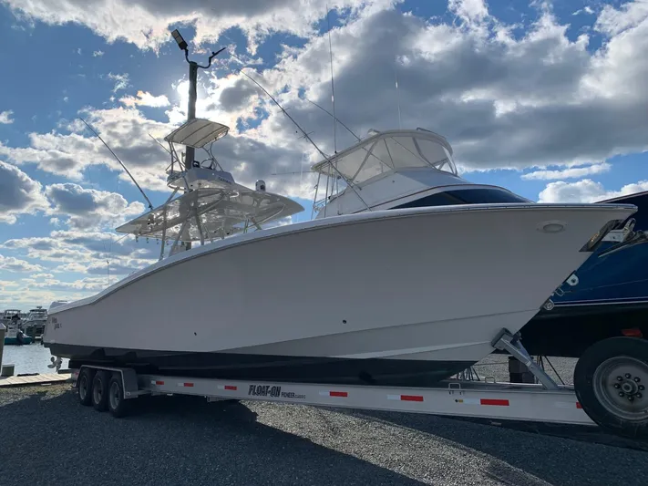 Must Sell!! Yacht Photos Pics 2016 Invincible 42 Open Fisherman boat on trailer under cloudy sky.