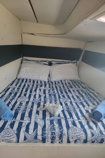 Freedom Yacht Photos Pics Cozy cabin bedroom in a 1993 Lagoon 42 yacht with nautical-themed bedding.