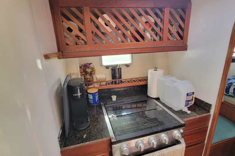 Freedom Yacht Photos Pics Compact kitchen in a 1993 Lagoon 42 yacht with stove, coffee maker, and storage.