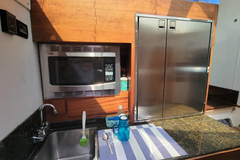 Freedom Yacht Photos Pics Modern kitchen area in a 1993 Lagoon 42 yacht with microwave and sink.