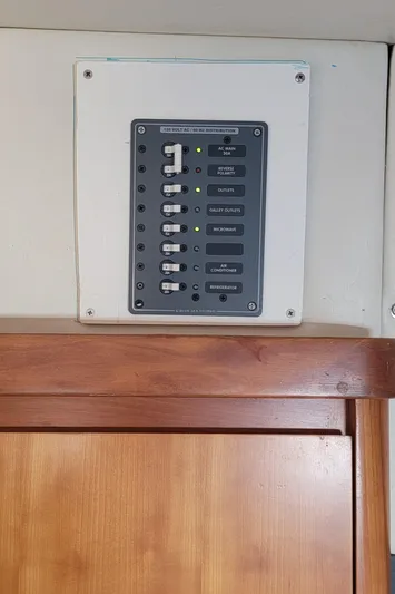 Freedom Yacht Photos Pics Electrical panel on a 1993 Lagoon 42 boat, mounted above a wooden cabinet.