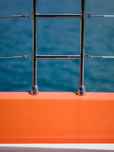 Blessed Yacht Photos Pics Orange railing and metal ladder on Sunreef 50 A yacht, 2024 model, with ocean background.