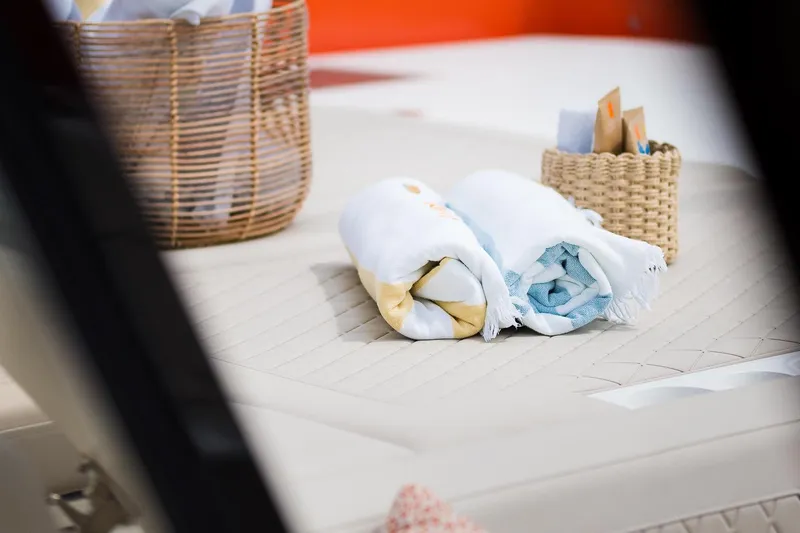 Blessed Yacht Photos Pics Rolled towels on Sunreef 50 A yacht, 2024 model, with wicker baskets in the background.