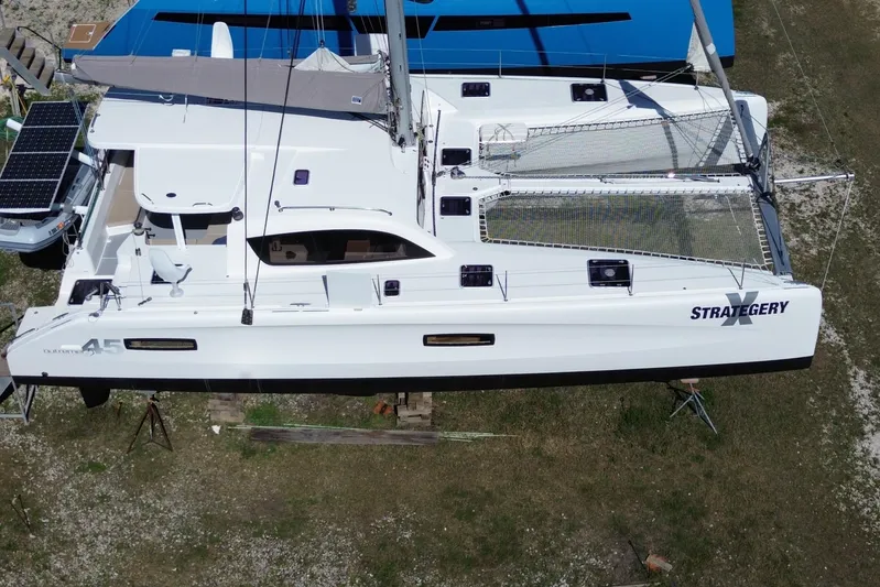 Strategery X Yacht Photos Pics 2014 Outremer 45 catamaran on land, featuring solar panels and netted deck.