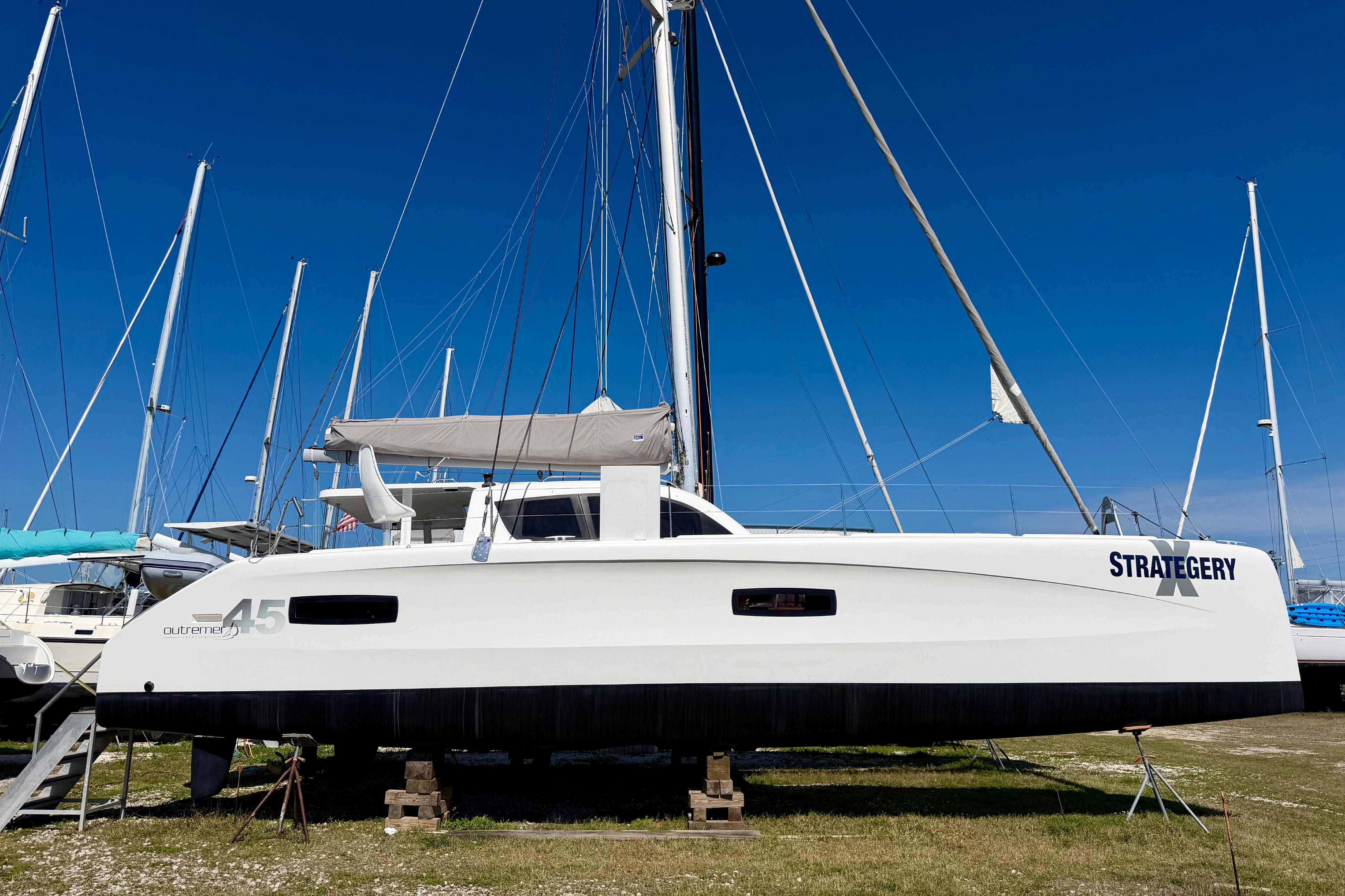 2014 Outremer 45 catamaran on land, clear blue sky background.