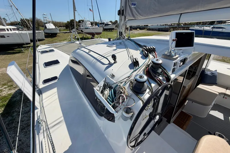Strategery X Yacht Photos Pics 2014 Outremer 45 catamaran deck with steering wheel and rigging, docked in a marina.
