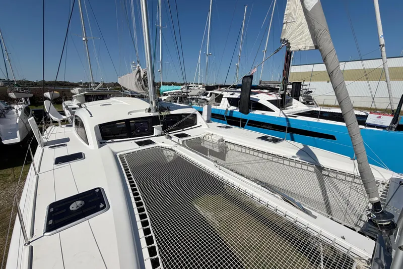Strategery X Yacht Photos Pics 2014 Outremer 45 catamaran with netted deck, docked alongside other boats.
