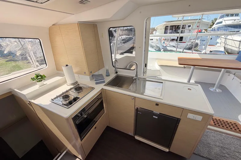Strategery X Yacht Photos Pics Modern kitchen interior of 2014 Outremer 45 catamaran with stove, sink, and outdoor view.