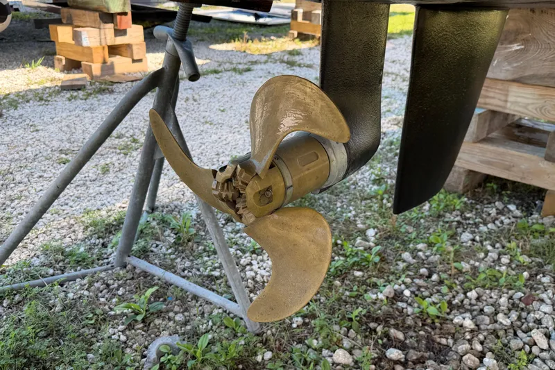 Strategery X Yacht Photos Pics Propeller of a 2014 Outremer 45 catamaran on a stand, surrounded by gravel.