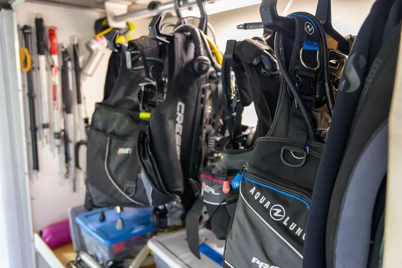  Yacht Photos Pics Diving gear storage with wetsuits and equipment in a well-organized space.