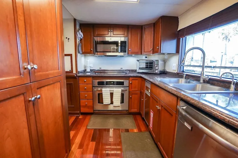  Yacht Photos Pics Luxurious kitchen in 1996 ABD 90 Explorer yacht with wooden cabinets and modern appliances.