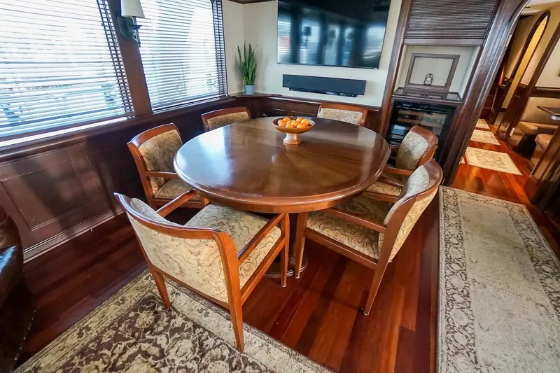  Yacht Photos Pics Luxurious dining area in 1996 ABD 90 Explorer yacht with elegant wooden table and chairs.