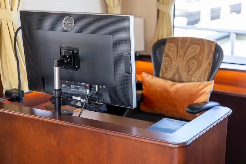  Yacht Photos Pics Office setup with Dell monitor, ergonomic chair, and orange cushion on a wooden desk.