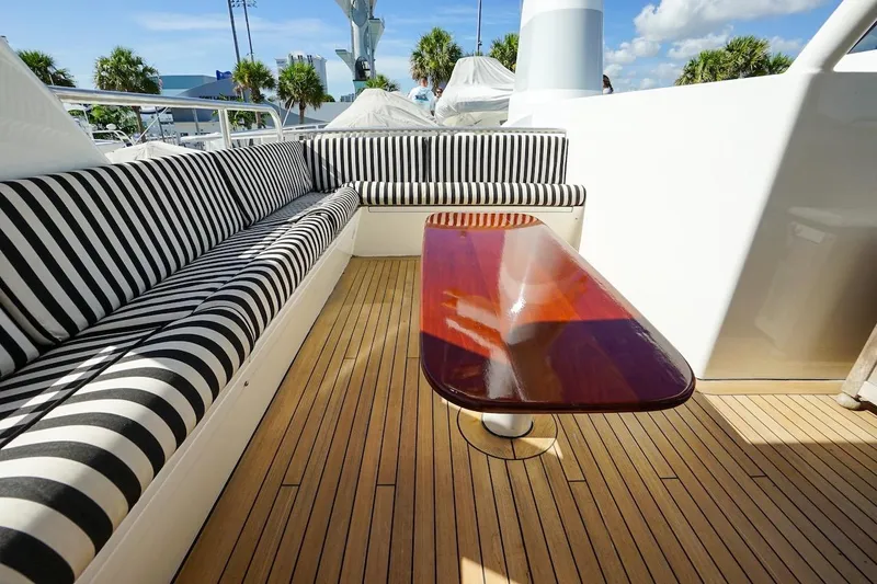  Yacht Photos Pics Luxurious 1996 ABD 90 Explorer yacht deck with striped seating and polished wooden table.