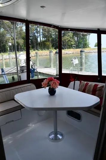 Lil Anna Yacht Photos Pics Interior of 2014 Fountaine Pajot Mahe 36 Evolution with table and seating, overlooking marina.