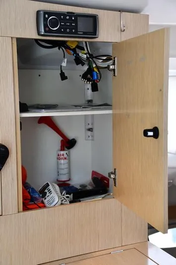 Lil Anna Yacht Photos Pics Open cabinet on 2014 Fountaine Pajot Mahe 36 Evolution yacht, showing electronics and safety equipment.