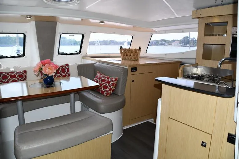 Lil Anna Yacht Photos Pics Interior of 2014 Fountaine Pajot Mahe 36 Evolution catamaran with dining area and kitchen.