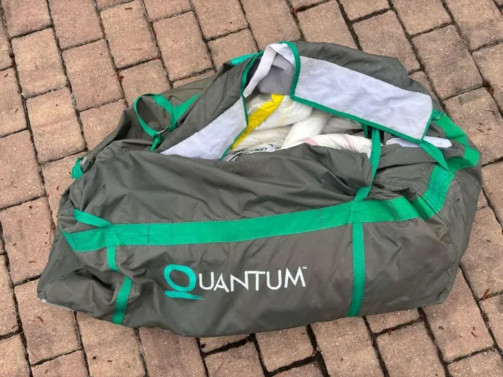 Lil Anna Yacht Photos Pics Bag labeled "Quantum" on brick surface, containing sailing equipment.