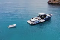 2022 Solaris Power 44 Open yacht on clear blue water with a small dinghy nearby.